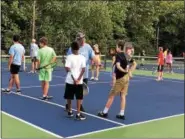  ?? LINDSAY BOWEN — FOR DIGITAL FIRST MEDIA ?? Jim Holt, director and founder of A Touch of Tennis, instructs two young players.