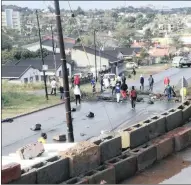  ??  ?? DAMAGE: Alleged land invaders in a street in Bonela early yesterday morning after a night of protests