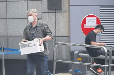  ??  ?? FAREWELL FOR NOW: A man carries a box out of the US consulate in Chengdu, China, yesterday.