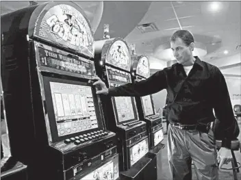  ?? ED REINKE/AP ?? Bobby Geiger, of Oaklawn Racing and Gaming, shows how wagers are placed on a video gaming machine.