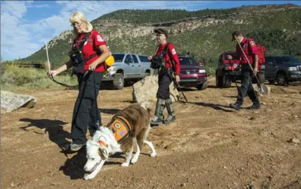  ?? ANGIE WANG, THE ASSOCIATED PRESS ?? Searchers head out at Tonto National Park, Ariz., Monday. Nine people were swept away and killed after a surprise flood hit an Arizona swimming hole.