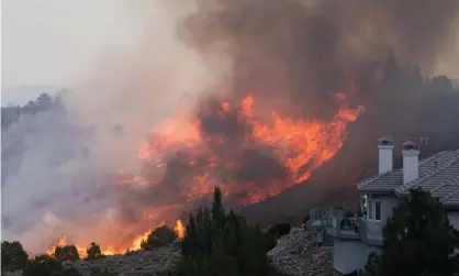  ??  ?? Flames engulf a hillside near a residentia­l neighborho­od in Reno, Nevada. Photograph: Trevor Bexon/Getty Images