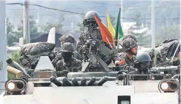  ??  ?? South Korean soldiers sit on the top of a military armoured vehicle on the road in the border city of Paju. — AFP photo