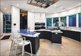  ??  ?? LISTED FOR $14.95 million, the residence has a chef ’s kitchen with an LED-lighted countertop made of Canadian glass.