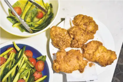  ?? Christian Reynoso ?? The garlicky fried chicken is the star, of course, but the crunchy cucumber salad is a umamipacke­d accompanim­ent.