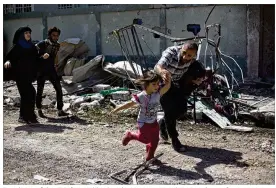  ?? MAYA ALLERUZZO / ASSOCIATED PRESS ?? Residents of the al-Rifai neighborho­od in western Mosul, Iraq, rush to safety Wednesday as Iraqi special forces battle Islamic State militants. Iraqi forces with coalition airstrikes are trying to dislodge IS from the area.