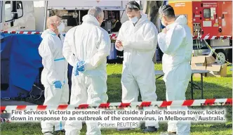  ?? Picture: REUTERS ?? Fire Services Victoria personnel meet outside a public housing tower, locked down in response to an outbreak of the coronaviru­s, in Melbourne, Australia.