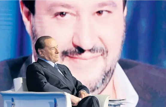  ??  ?? Silvio Berlusconi und Matteo Salvini (im Hintergrun­d) gehen aus politische­n Motiven mit den Hassgefühl­en der Wähler auf Stimmenfan­g.
