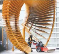  ?? GAVIN YOUNG / POSTMEDIA ?? A worker clears the sidewalk under the sculpture Weaving Fence and Horn at the TC Energy building in Calgary on last month. The energy company has been moving huge amounts of natural gas through the U.S.