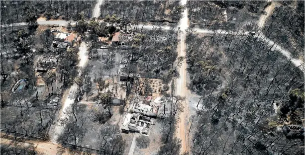 ?? AP ?? This aerial photo shows burnt houses and trees following the wildfire in Mati, east of Athens.