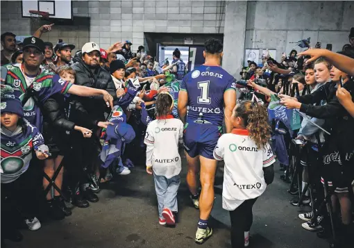  ?? PHOTOSPORT ?? Roger Tuivasa-Sheck walks back to the Warriors’ dressing room with two of his three children after their win over the Knights.