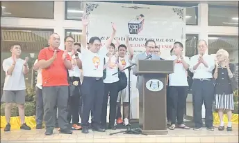  ?? ?? Chong (second left) raising his arm in victory after henry announced the official resultsi while his wife drace tan (on his left) and his parents Chong Siew Chiang (third right)i Sim vaw Sik (second right) along with other party members applaud.