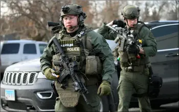  ?? ANTONIO PEREz/ChICAGO TRIBuNE VIA AP ?? Police officers armed with rifles gather was reported in Aurora, Ill., on Friday. at the scene where an active shooter