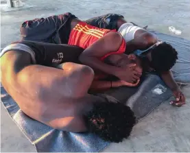  ?? (AP Photo/Hazem Ahmed) ?? Rescued migrants rest on a beach some 100 kilometres east of Tripoli on Thursday. The UN refugee agency and the Internatio­nal Rescue Committee say up to 150 may have perished at sea off the coast of Libya, while 137 were rescued