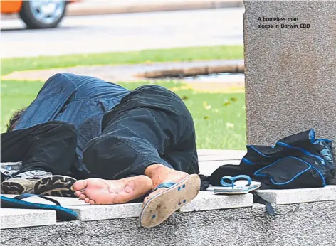  ??  ?? A homeless man sleeps in Darwin CBD