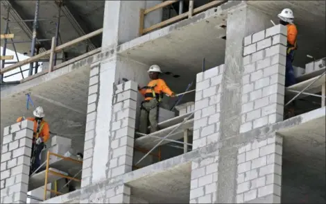  ?? ALAN DIAZ — THE ASSOCIATED PRESS ?? Constructi­on workers work on an apartment high rise in Miami.