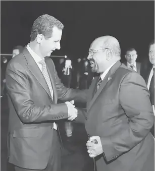  ?? — Gambar SANA/AFP ?? SELAMAT DATANG: Gambar serahan Agensi Berita Arab Syria (SANA) pada Ahad menunjukka­n Assad (kiri) mengalu-alukan Bashir yang tiba di Damsyik, Syria.