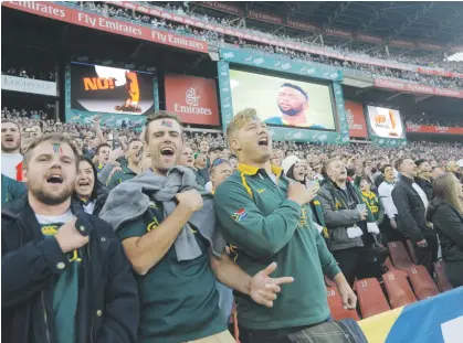  ??  ?? IN FULL VOICE. Springbok captain, Siya Kolisi (on screen) sings the national anthem with supporters in the stadium prior to the team facing England at Ellis Park.