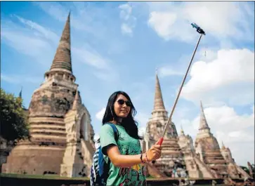  ?? Diego Azubel European Pressphoto Agency ?? A NEW study found that travel is responsibl­e for about 8% of all global greenhouse gas emissions, more than double the figure in earlier studies. Above, a tourist takes a selfie in Ayutthaya, north of Bangkok, Thailand.