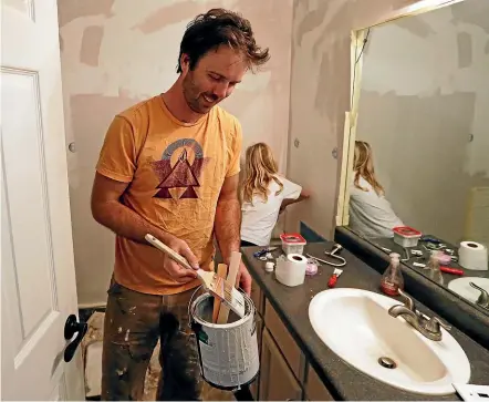  ?? AP ?? Federal contractor Chris Erickson paints his bathroom in North Salt Lake, Utah yesterday during the US government shutdown. Erickson says he’ll run out of vacation days if the shutdown continues. The father of three will then start dipping into his savings, and may have to postpone a wedding anniversar­y trip with his wife. He is unlikely to be reimbursed for the lost days, because he is a contractor.