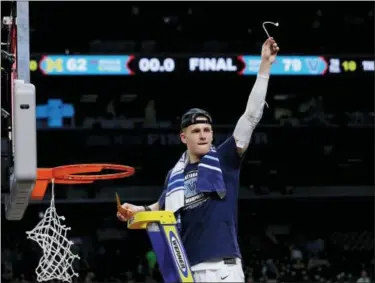  ?? DAVID J. PHILLIP — THE ASSOCIATED PRESS ?? Villanova’s Donte DiVincenzo cuts a piece of net for himself in celebratio­n of a national championsh­ip victory over Michigan.