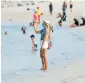  ??  ?? A woman wears a face mask on a beach in Dubai