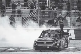  ?? THE ASSOCIATED PRESS ?? Christophe­r Bell celebrates near the finish line after winning the NASCAR Camping World Truck Series’ Active Pest Control 200 on Saturday at Atlanta Motor Speedway.