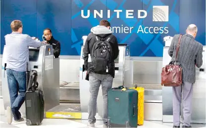  ??  ?? Travelers check in on April 12 at the United Airlines Premier Access at O’Hare. | JOSHUA LOTT/ AFP/ GETTY IMAGES