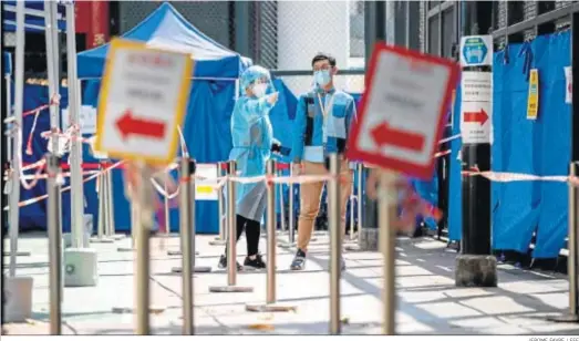  ?? JEROME FAVRE / EFE ?? Una sanitaria señala la entrada a un centro de test de coronaviru­s en Hong Kong.