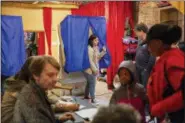  ?? HEATHER KHALIFA/THE PHILADELPH­IA INQUIRER VIA AP ?? Mayra Madera, center, exits the voting booth inside Studio 1831, a yoga studio in Philadelph­ia on Tuesday, Nov. 6.