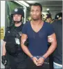  ?? LU HANXIN / XINHUA ?? Chinese police hand over fugitive Naquan Ferguson to police from the United States in Guangzhou on Friday.