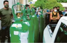  ?? Foto: Sandro Pereira, dpa ?? Menschen stehen in Manaus Schlange, um in einer Fabrik Sauerstoff für ihre an Co‰ rona erkrankten Angehörige­n zu bekommen.