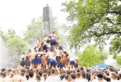  ?? CAPITAL GAZETTE FILE ?? Naval Academy first-year students climb the Herndon obelisk monument to replace a Dixie Cup on top with an upperclass­man’s hat.