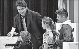  ?? MINAS PANAGIOTAK­IS/GETTY ?? Canada’s Justin Trudeau is surrounded by his children as he casts his vote on Monday.