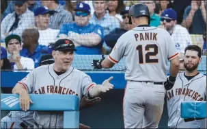  ?? ROBERT GAUTHIER/TRIBUNE NEWS SERVICE ?? San Francisco Giants manager Bruce Bochy greets Joe Panik (12) after a solo home run against the Los Angeles Dodgers in Los Angeles on March 29, 2018.
