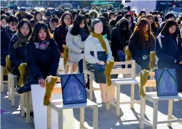  ?? — AFP ?? Women sit around a statue of a ‘ comfort woman’ ( C) during an installati­on of empty chairs during a performanc­e event, commemorat­ing the death of eight former sex slaves this year, in Seoul on Wednesday. South Korea said that a 2015 deal intended to...