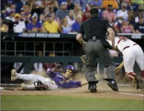  ?? NATI HARNIK — THE ASSOCIATED PRESS ?? LSU shortstop Kramer Robertson scores on a single by Antoine Duplantis, as Florida State catcher Cal Raleigh attempts to make the tag in the ninth inning at the College World Series on Wednesday.