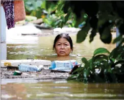  ?? Pictures: REUTERS ?? NECK DEEP: A woman wades through a submerged street at the Unesco heritage ancient town of Hoi An after typhoon Damrey hits Vietnam.