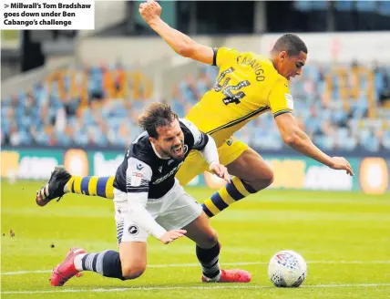  ??  ?? > Millwall’s Tom Bradshaw goes down under Ben Cabango’s challenge