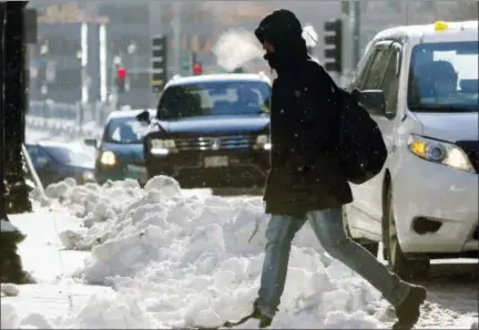  ?? ASSOCIATED PRESS ?? A pedestrian crosses the street as the temperatur­e hovers in the single-digits in downtown Boston. The National Weather Service said there’s the potential for record-breaking cold this week in New England.