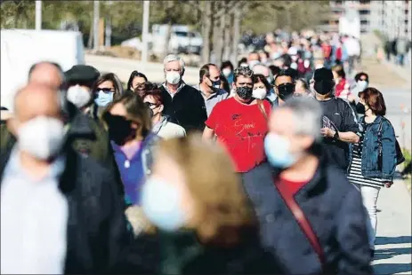  ?? SERGIO PEREZ / REUTERS ?? Cues a l’entrada de l’hospital Zendal per vacunar-se a començamen­ts d’abril