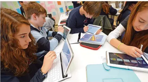  ?? FOTO: ARNE DEDERT/DPA ?? Immer mehr Schulen setzen auf interaktiv­es Lernen etwa mit Tablet-Computern. Doch wer die Geräte instand hält, ist offen. Lehrer fürchten, dass die Wartung der Geräte zusätzlich­e Arbeit für sie bedeuten wird.