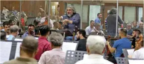  ?? — AFP photos ?? Iraqi National Symphony Orchestra conductor Mohammed Amin Ezzat leads musicians during a rehearsal at Baghdad’s School of Music and Ballet.