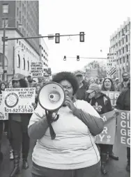  ?? JOE RONDONE/THE COMMERCIAL APPEAL ?? Amber Sherman chants through a megaphone as she leads a group down Adams Avenue during the Women's March downtown Memphis on Jan. 19, 2019.