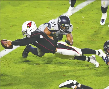  ?? NORM HALL/ GETTY IMAGES ?? Cardinals quarterbac­k Kyler Murray dives into the end zone for a touchdown against the Seattle Seahawks on Sunday night in Glendale, Ariz. The Cardinals overcame a late 10-point deficit to win 37-34 on a field goal in overtime. It was Seattle's first loss of the season.