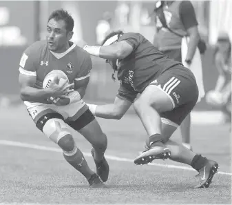  ?? THE CANADIAN PRESS ?? Canada’s Phil Mack, of Victoria, avoids a tackle by the U.S.’s Mike Te’o.