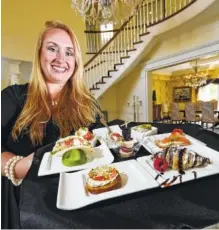  ?? STAFF PHOTO BY TIM BARBER ?? Tara Plumlee holds a tray of assorted canapes in the foyer of the Bell Mill Mansion wedding venue in Ooltewah.