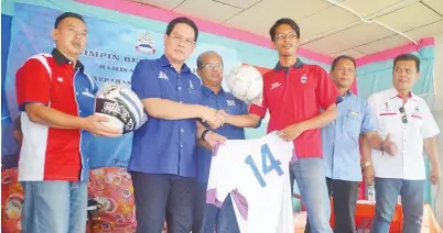  ??  ?? SADDI menyalurka­n bantuan peralatan sukan kepada pemimpin belia Sepinong.