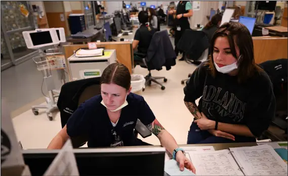  ?? HELEN H. RICHARDSON — THE DENVER POST ?? Nurses Alli Novotny, left, and Emma Cave work at the nurse’s charge station in the emergency department at Uchealth University of Colorado Hospital in Aurora on Monday.