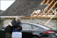  ?? THOMAS GRANING — THE ASSOCIATED PRESS ?? Neighbors Alfred Lee and Grace Bazzy hug in front of another neighbor’s damaged home along Elvis Presley Drive in Tupelo, Miss.